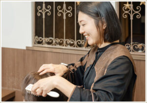 櫛で髪をとかしている美容師