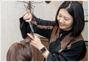 髪を切りながら微笑んでいる女性