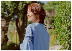 ウィッグをつけて太陽の光を浴びる女性